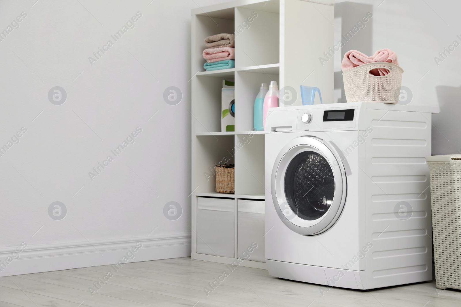 Photo of Modern washing machine in laundry room interior. Space for design