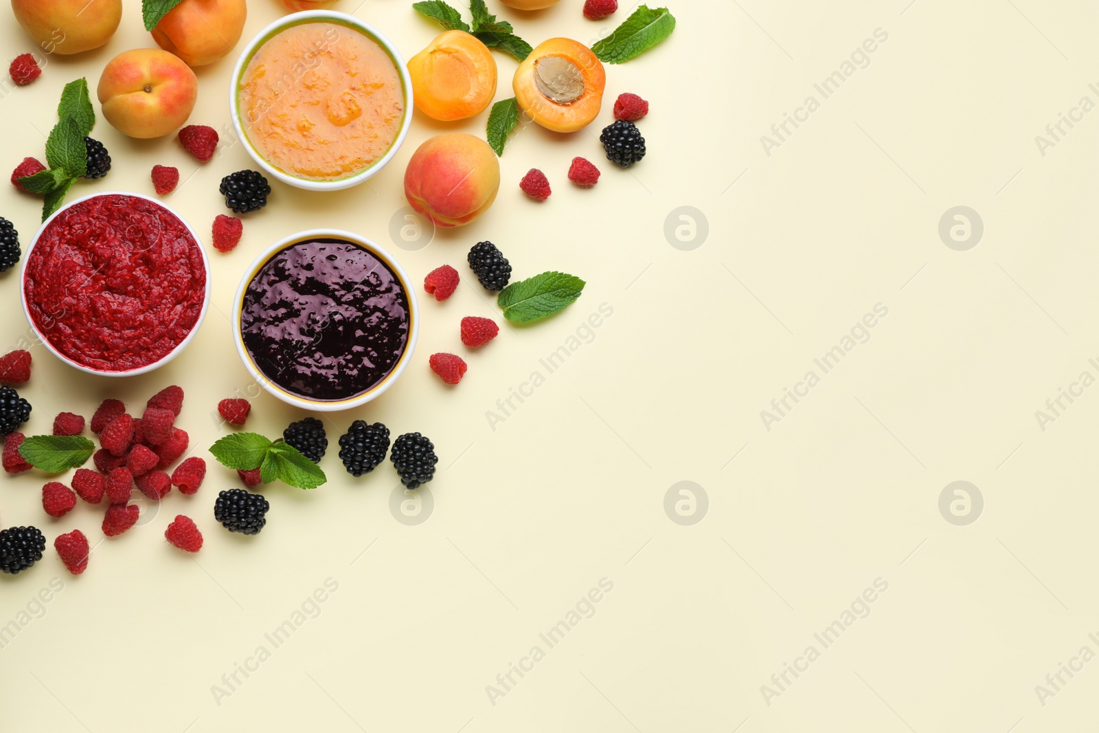 Photo of Different puree in bowls and fresh ingredients on beige background, flat lay. Space for text