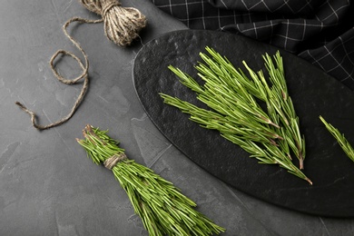 Photo of Fresh rosemary twigs on grey background, above view