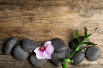 Photo of Stones, bamboo, orchid flower and space for text on wooden background, flat lay. Zen lifestyle