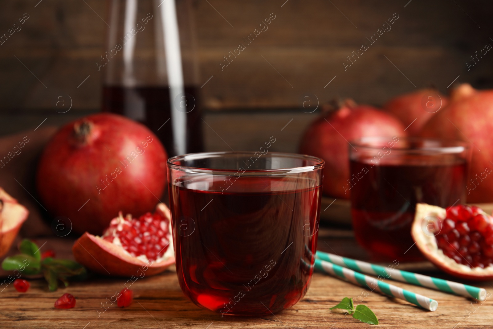 Photo of Delicious pomegranate juice and fresh fruits on wooden table