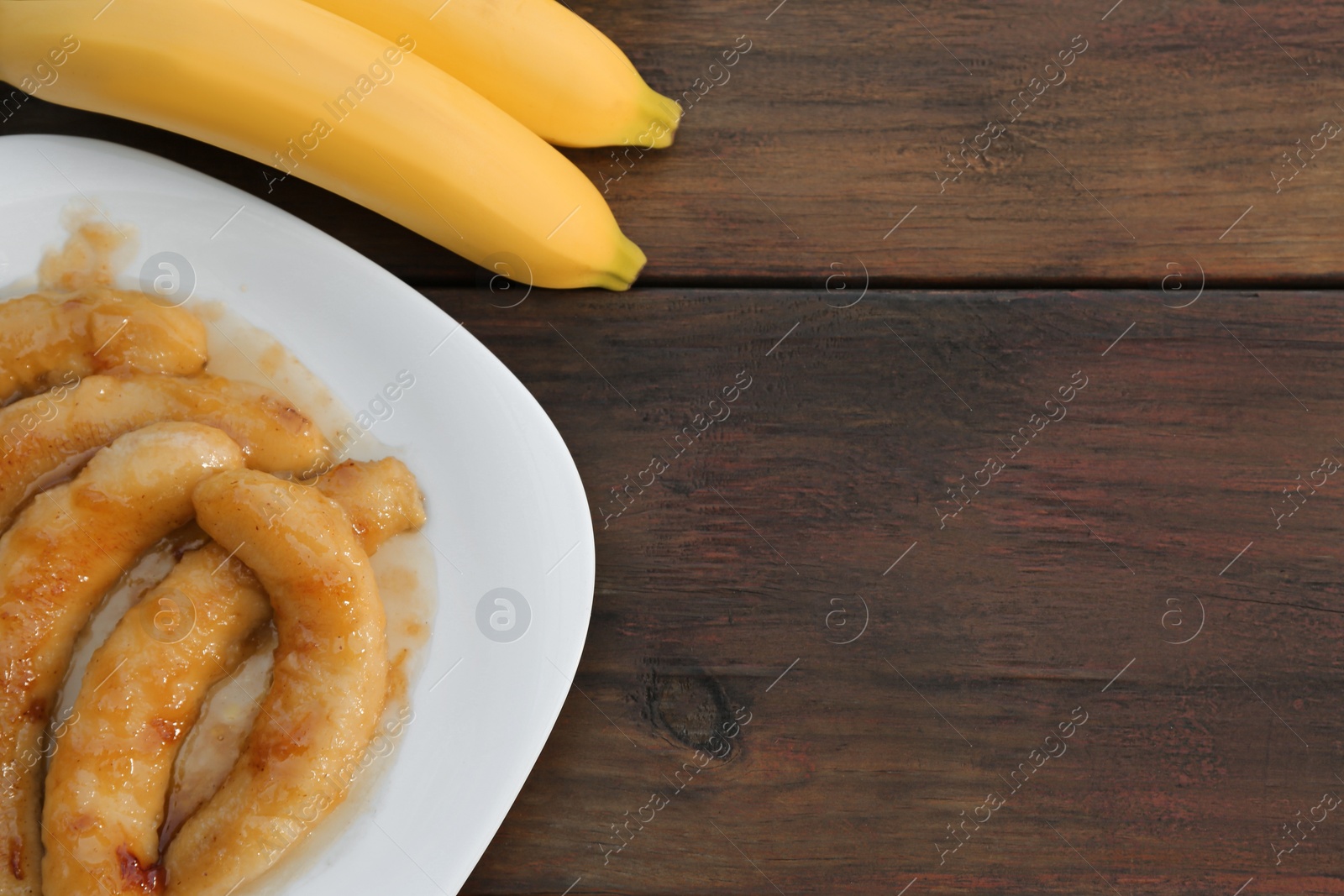 Photo of Delicious fried and fresh bananas on wooden table, flat lay. Space for text