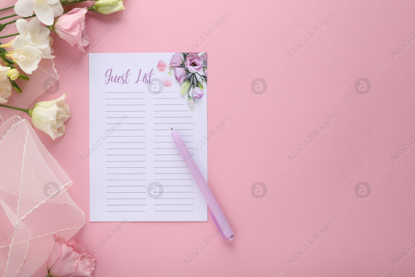 Photo of Guest list, pen, tulle fabric and beautiful flowers on pink background, flat lay. Space for text