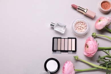 Photo of Flat lay composition with different makeup products and beautiful spring flowers on gray background, space for text