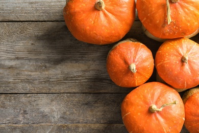 Orange pumpkins on wooden background, flat lay composition with space for text. Autumn holidays