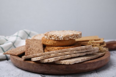 Photo of Rye crispbreads, rice cakes and rusks on white textured table, space for text