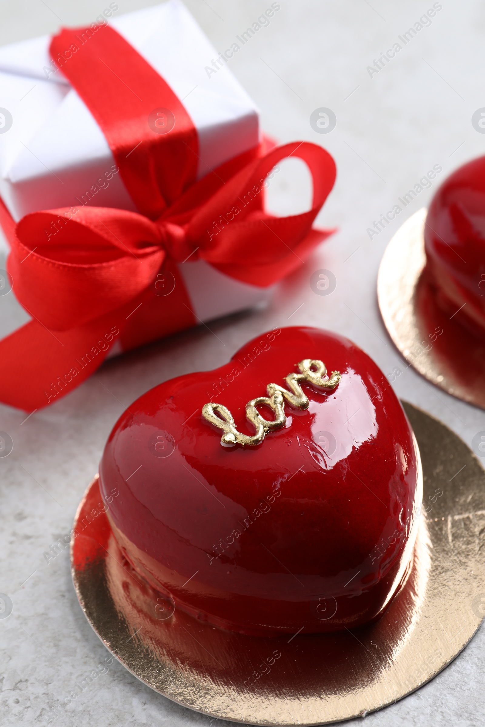 Photo of St. Valentine's Day. Delicious heart shaped cake and gift on light table, closeup