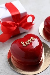 Photo of St. Valentine's Day. Delicious heart shaped cake and gift on light table, closeup