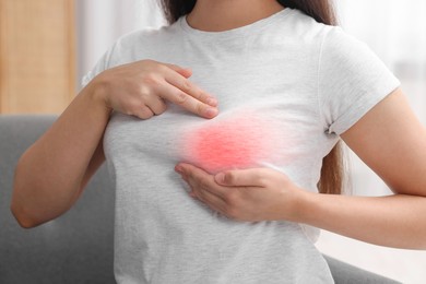 Image of Woman doing breast self-examination at home, closeup