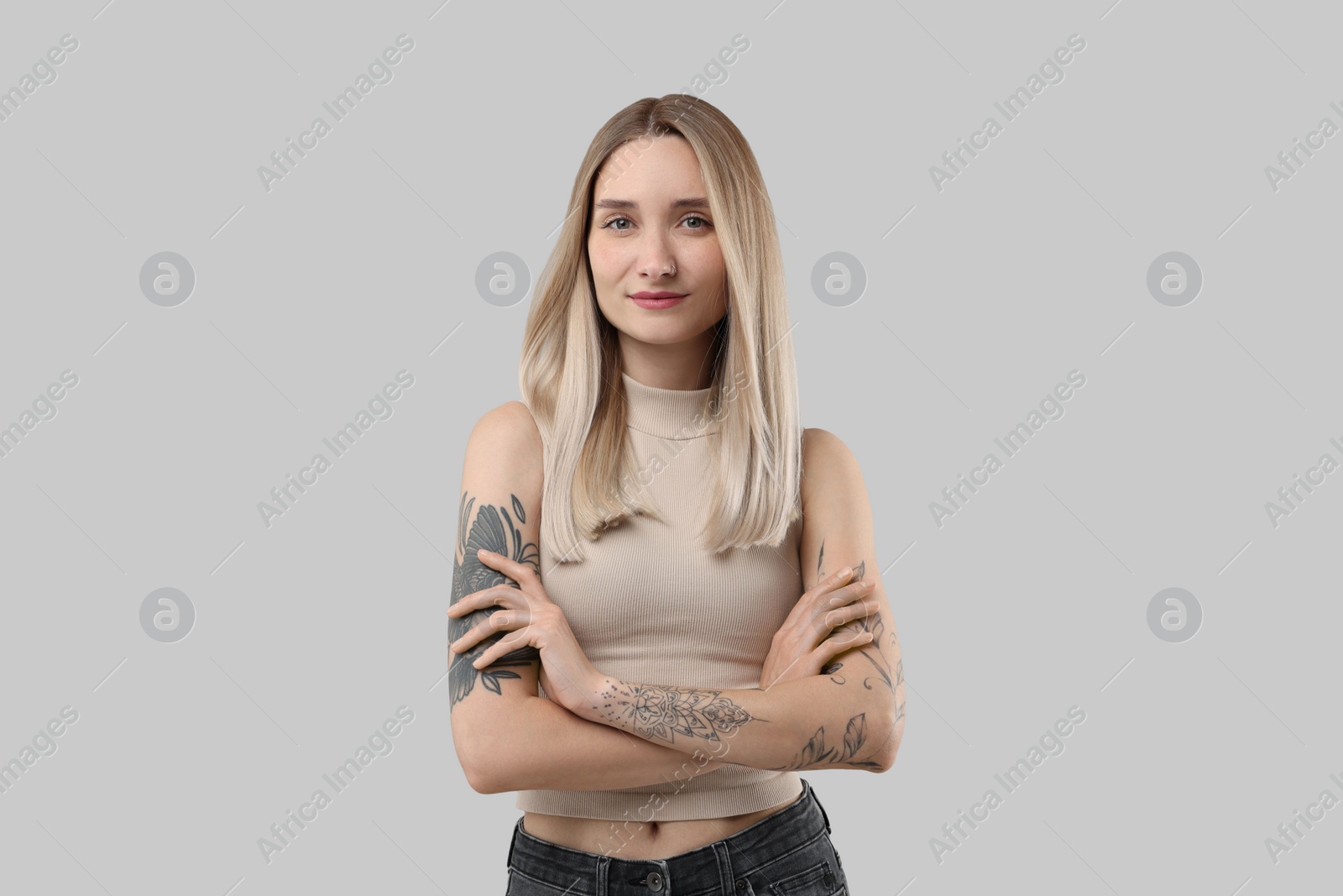 Photo of Portrait of beautiful tattooed woman on gray background