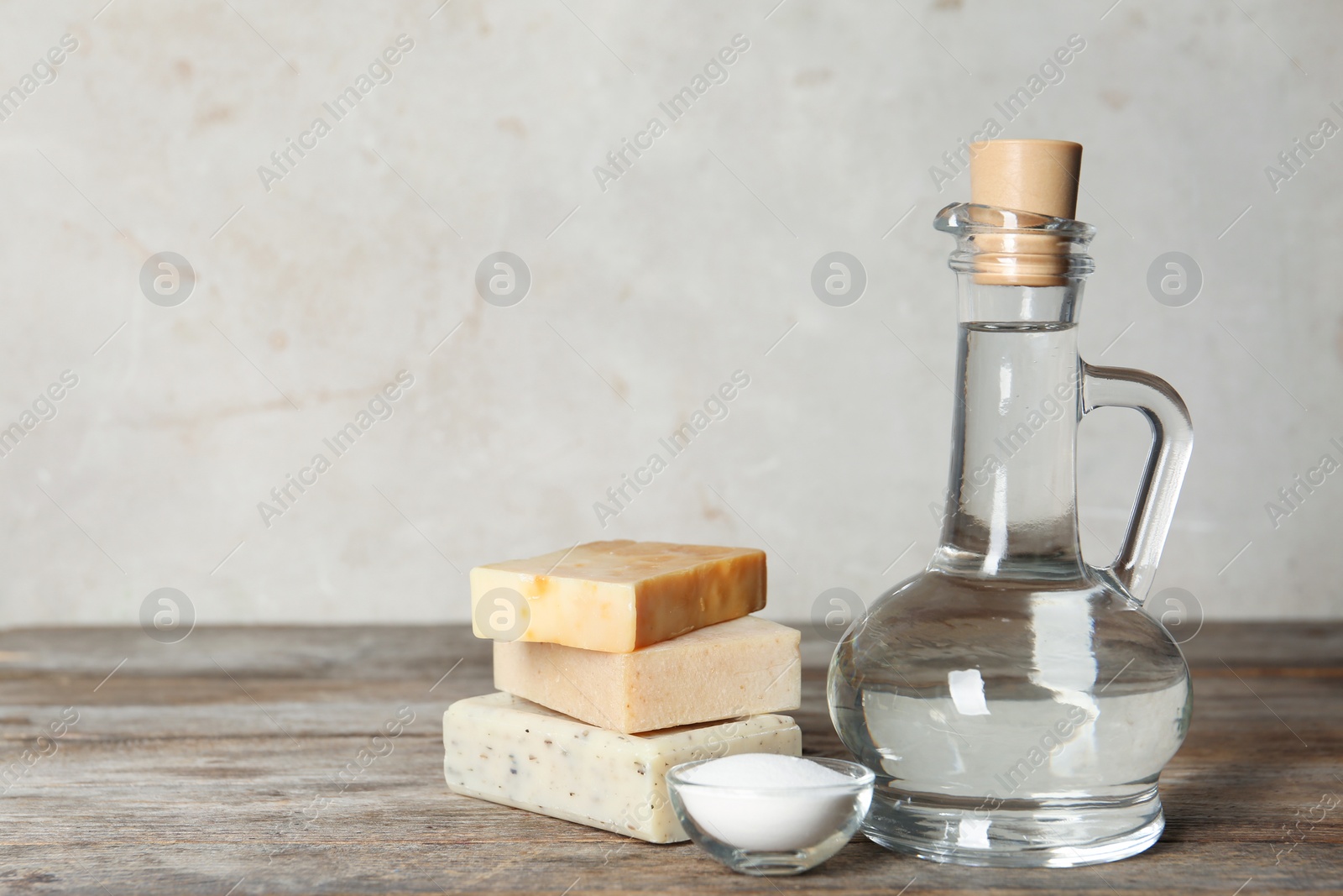 Photo of Composition with vinegar, baking soda and soap bars for cleaning on table. Space for text