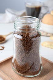 Photo of Open jar of instant coffee on white table