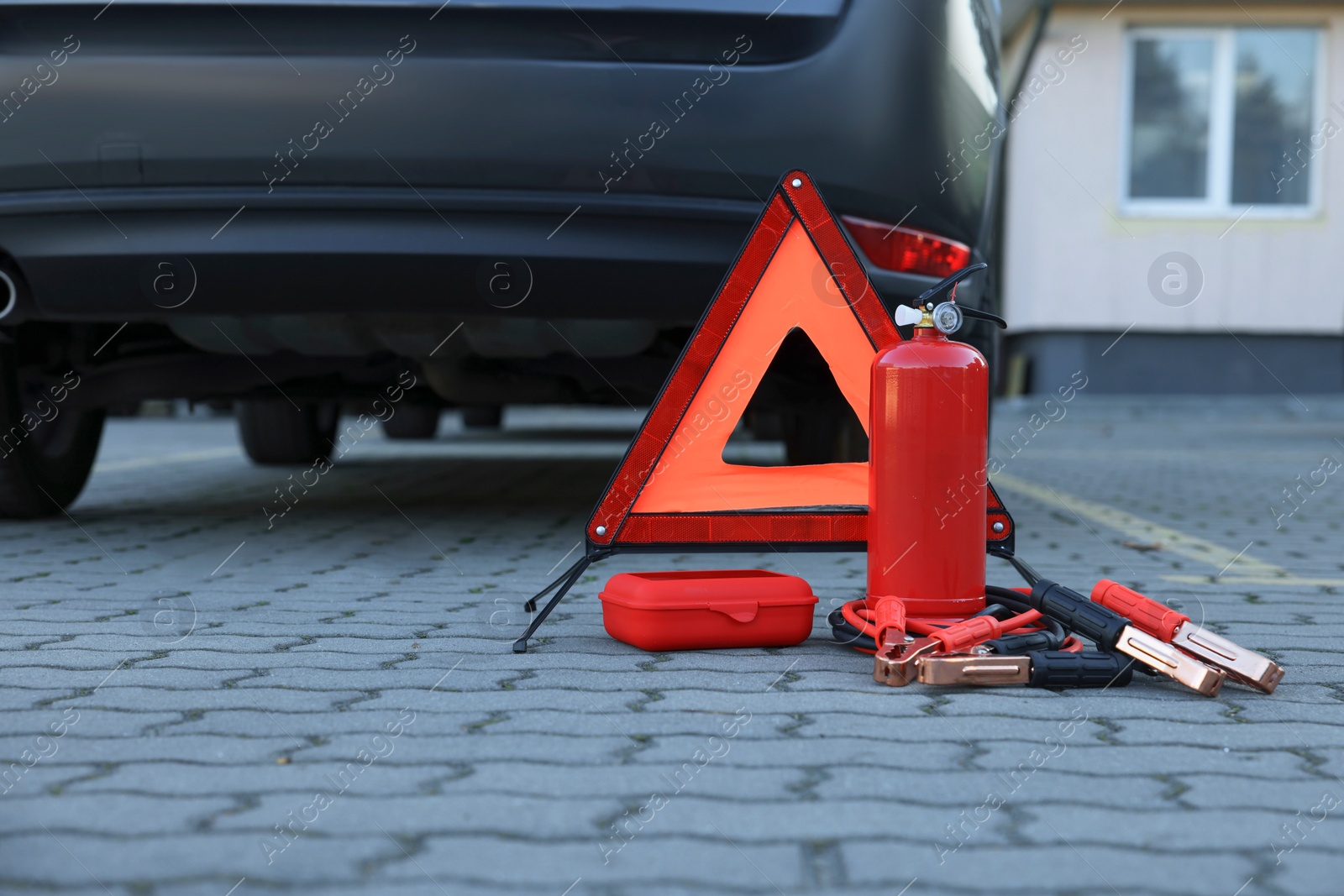 Photo of Emergency warning triangle and safety equipment near car, space for text