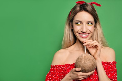 Photo of Young woman with fresh coconut on green background, space for text. Exotic fruit