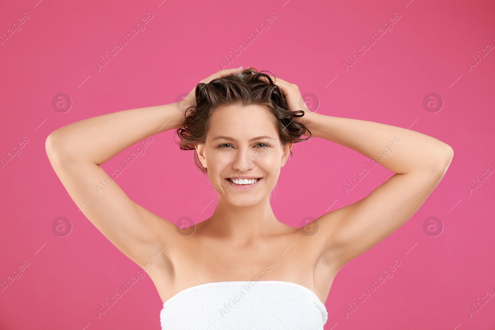 Photo of Beautiful young woman washing hair on pink background