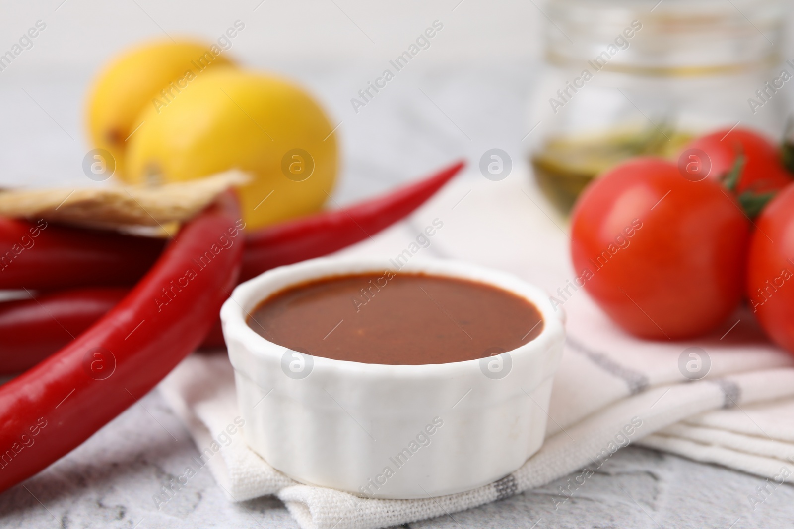 Photo of Fresh marinade and different ingredients on light grey table, closeup