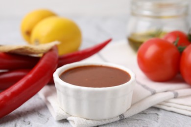 Photo of Fresh marinade and different ingredients on light grey table, closeup