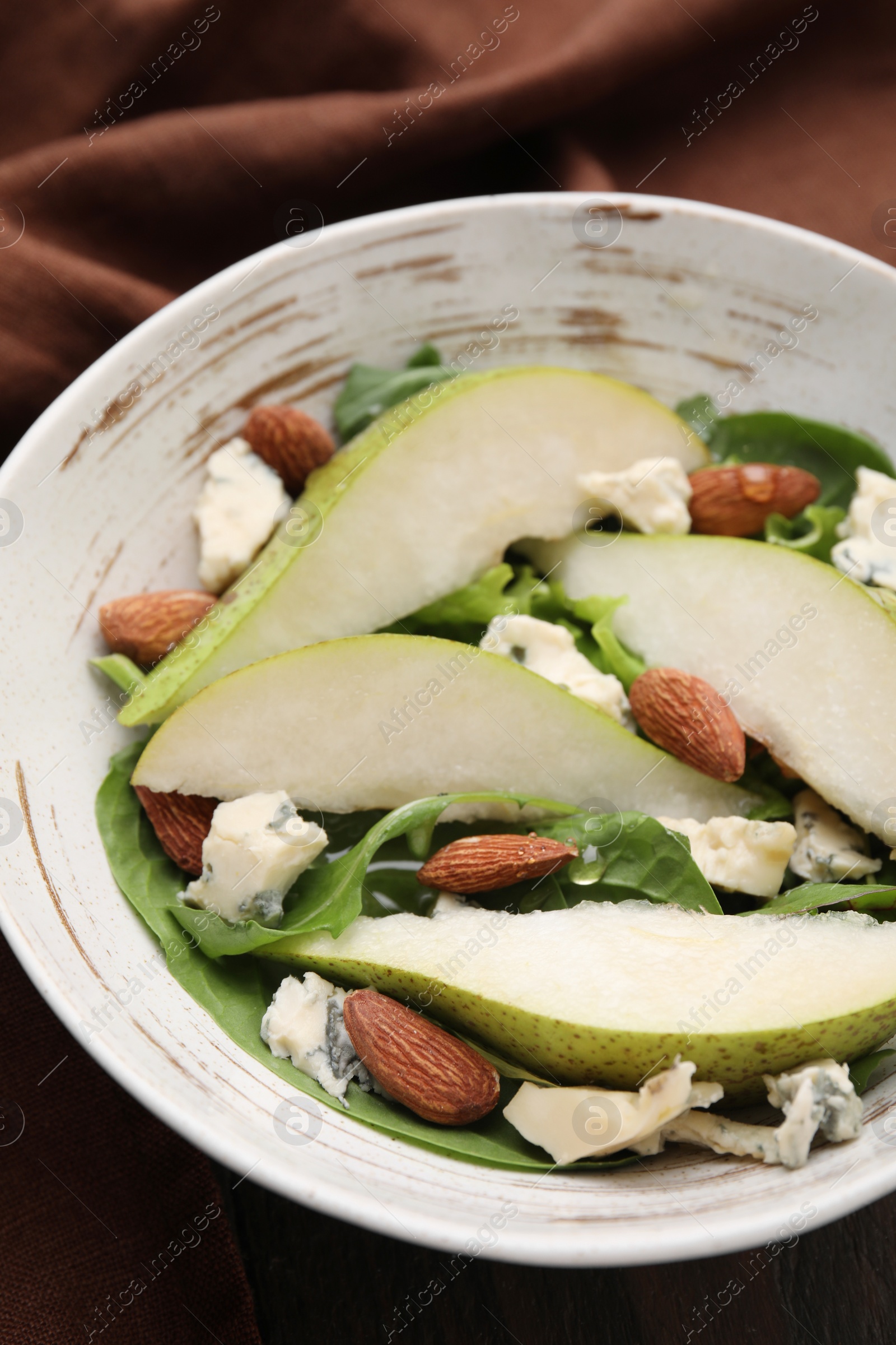 Photo of Delicious pear salad in bowl on table, closeup