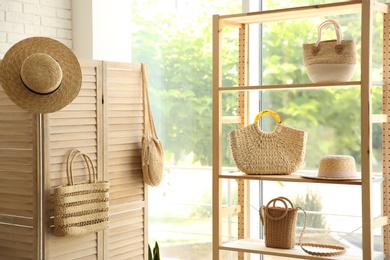 Photo of Stylish knitted woman's bags on shelves in boutique