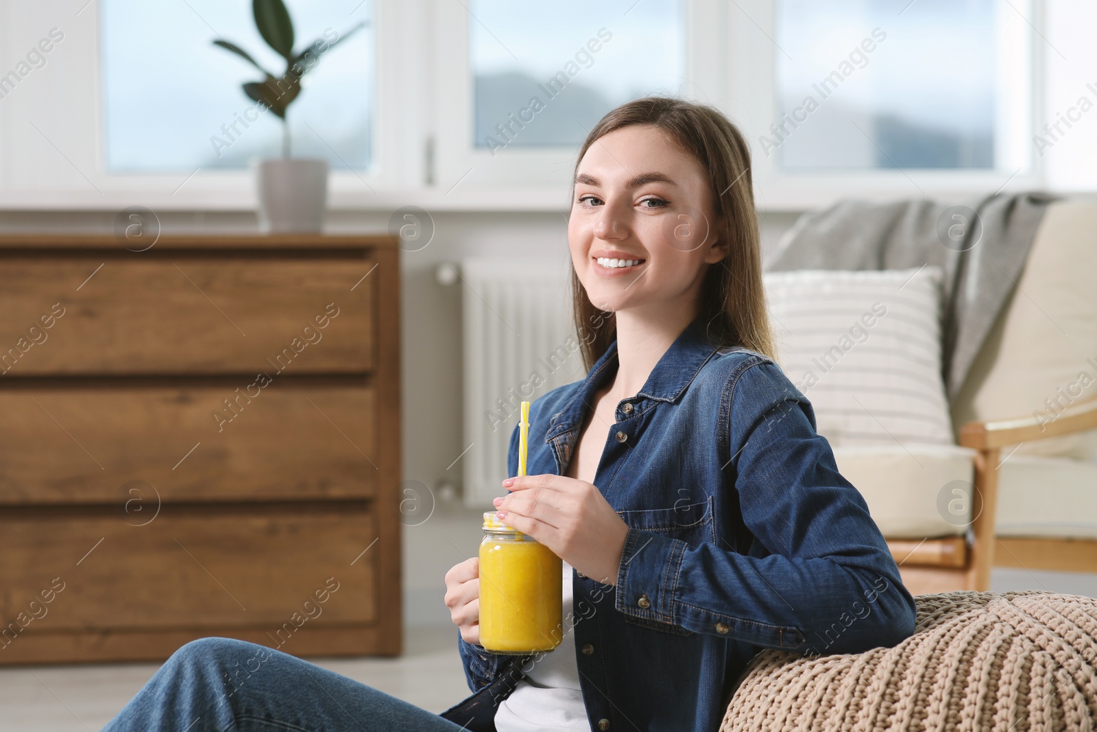 Photo of Beautiful young woman with delicious smoothie at home. Space for text