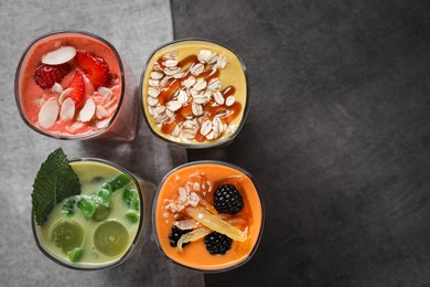 Many different delicious smoothies on grey table, flat lay. Space for text