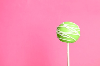 Photo of Bright delicious cake pop on color background. Space for text