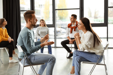 Psychotherapist working with patient in group therapy session indoors