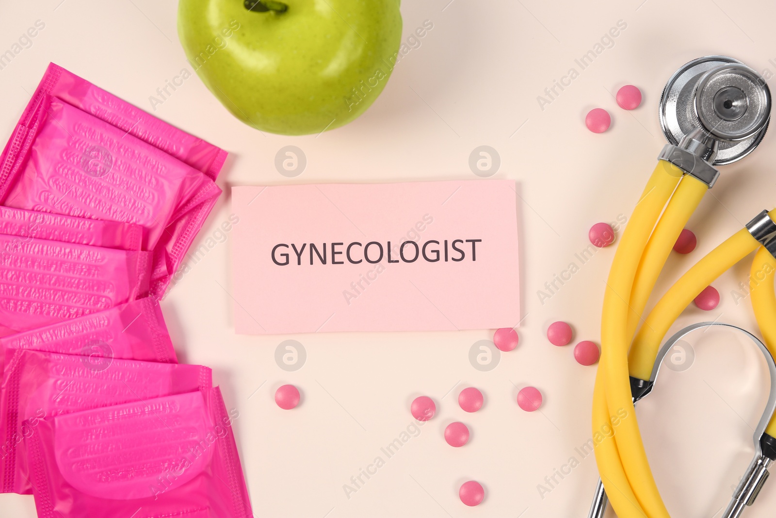 Photo of Flat lay composition with stethoscope, menstrual pads and pills on color background. Gynecological checkup