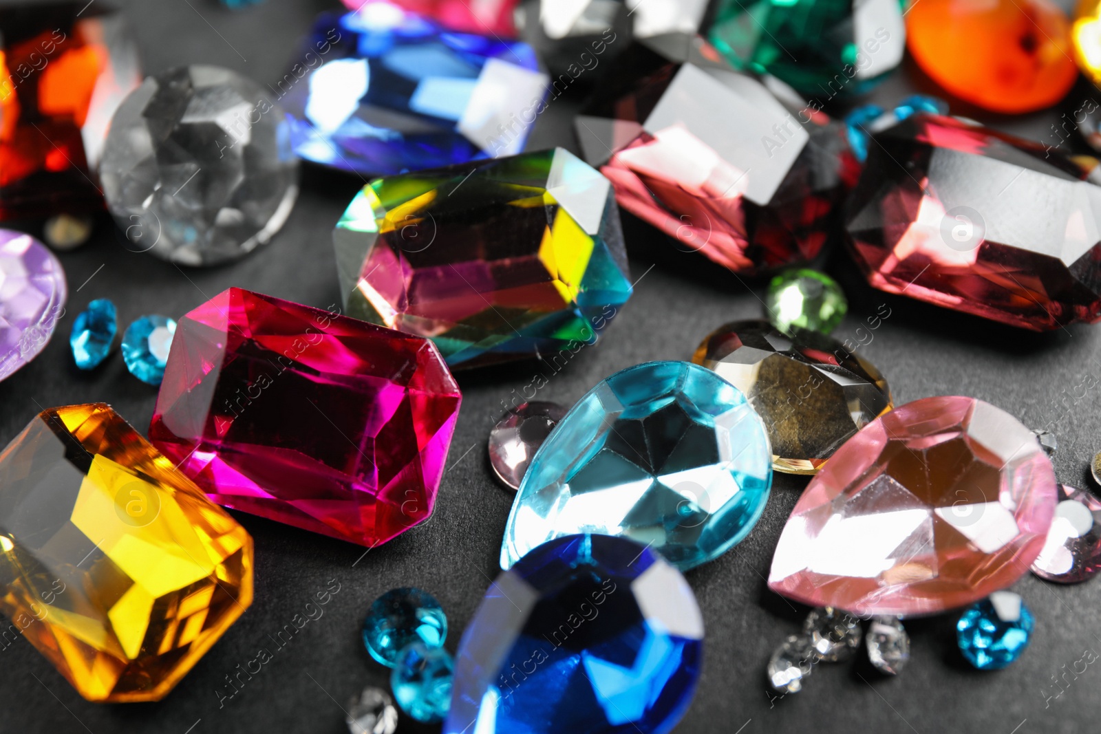 Photo of Different beautiful gemstones on black background, closeup