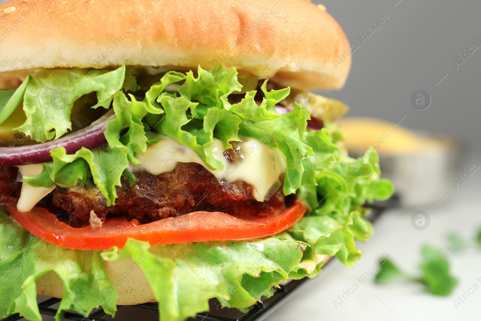 Photo of Delicious burger with beef patty and lettuce on table, closeup