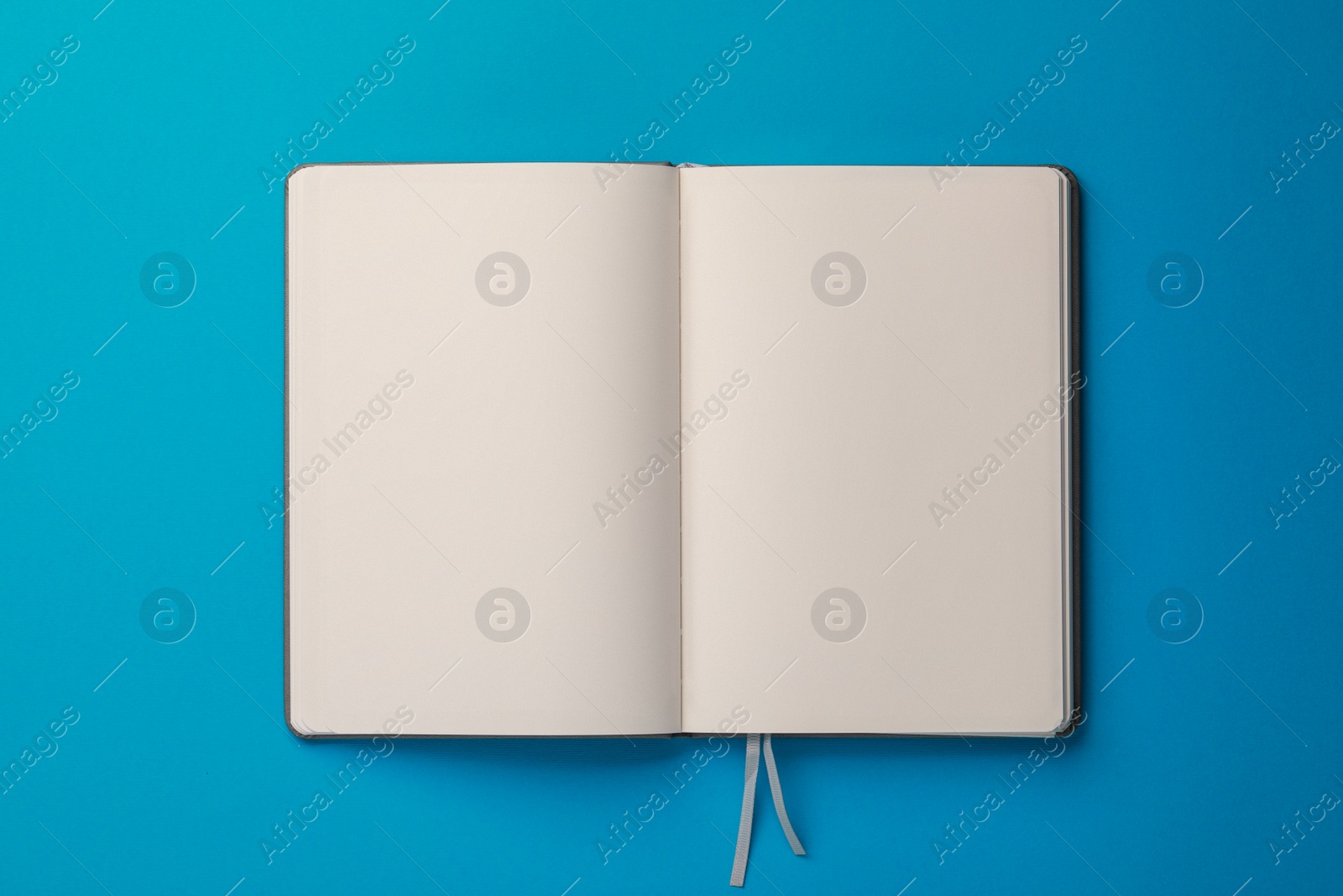 Photo of Blank notebook on light blue background, top view