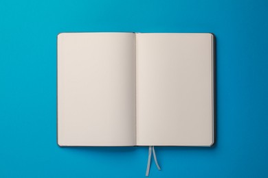 Blank notebook on light blue background, top view