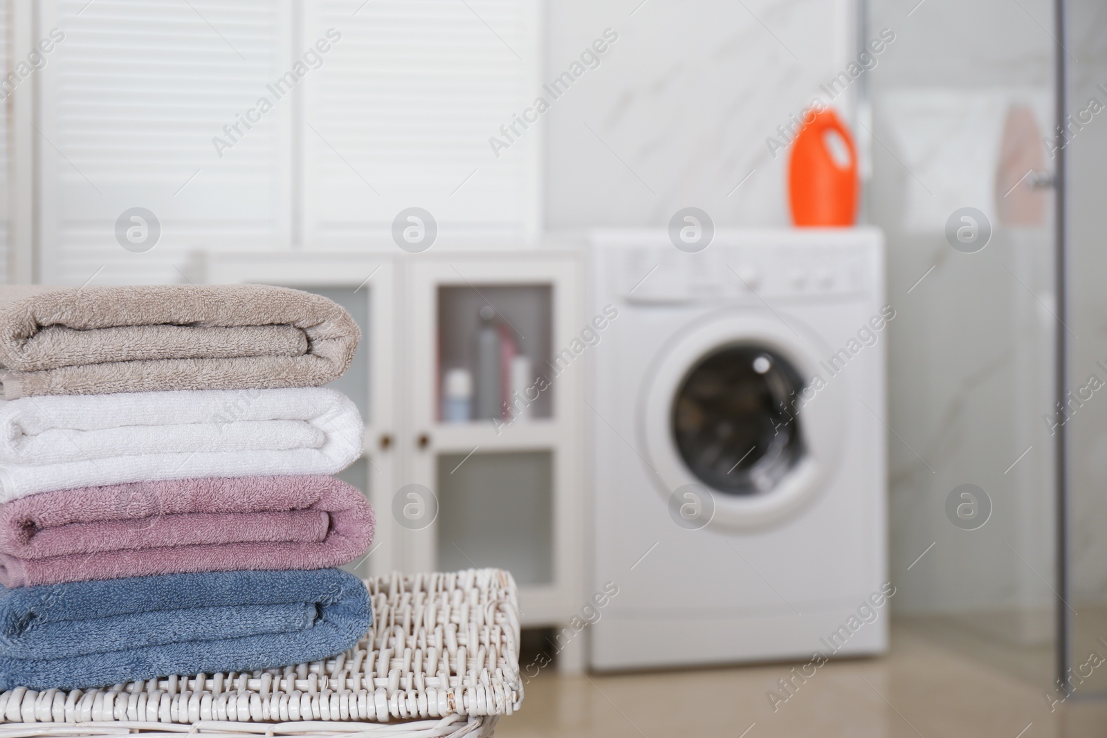 Photo of Stack of fresh towels in laundry room, space for text