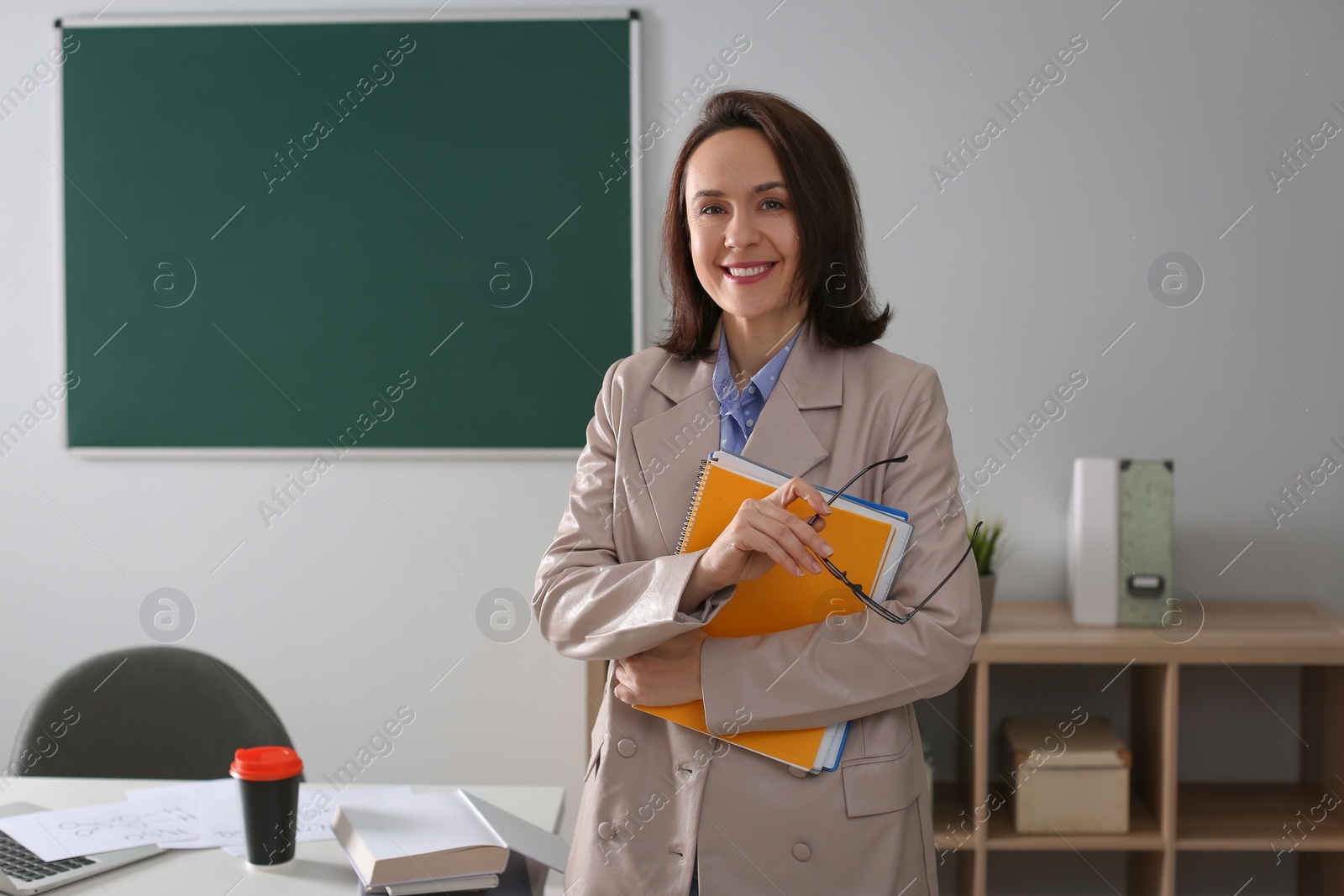 Photo of Portrait of teacher near desk in classroom