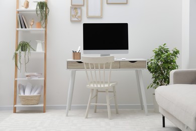 Spacious workspace with desk, chair, computer and potted plants at home