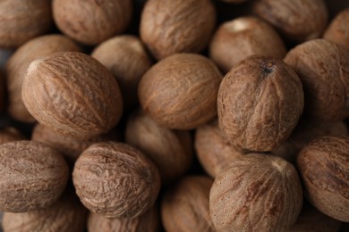 Photo of Many whole nutmegs as background, top view