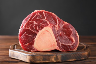 Photo of Piece of raw beef meat on wooden table, closeup