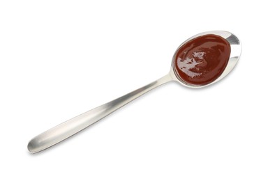 Tasty barbecue sauce in spoon isolated on white, top view