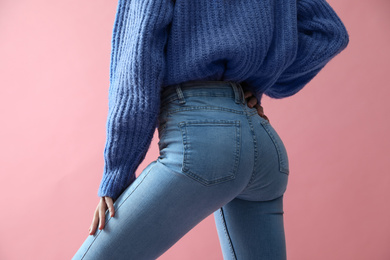 Woman wearing jeans on pink background, closeup