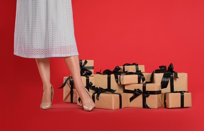 Woman and gift boxes on red background, closeup. Black Friday