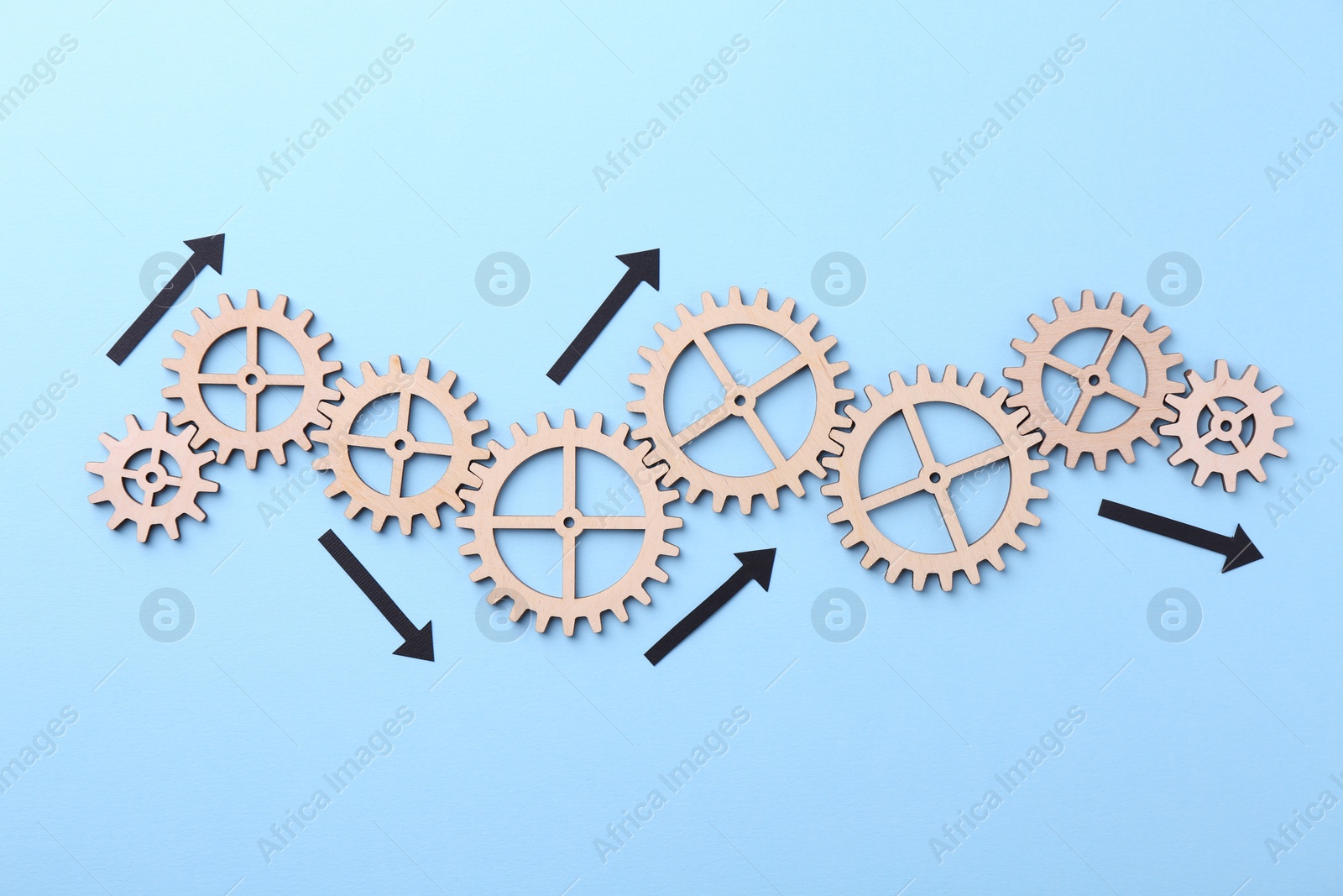 Photo of Business process organization and optimization. Scheme with wooden figures and arrows on light blue background, top view