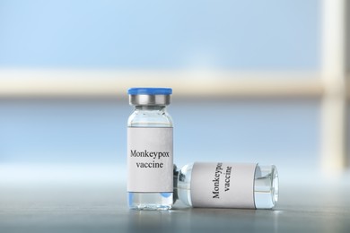 Monkeypox vaccine in vials on table, space for text