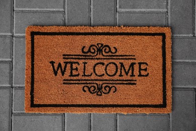 Doormat with word Welcome on pavement, top view
