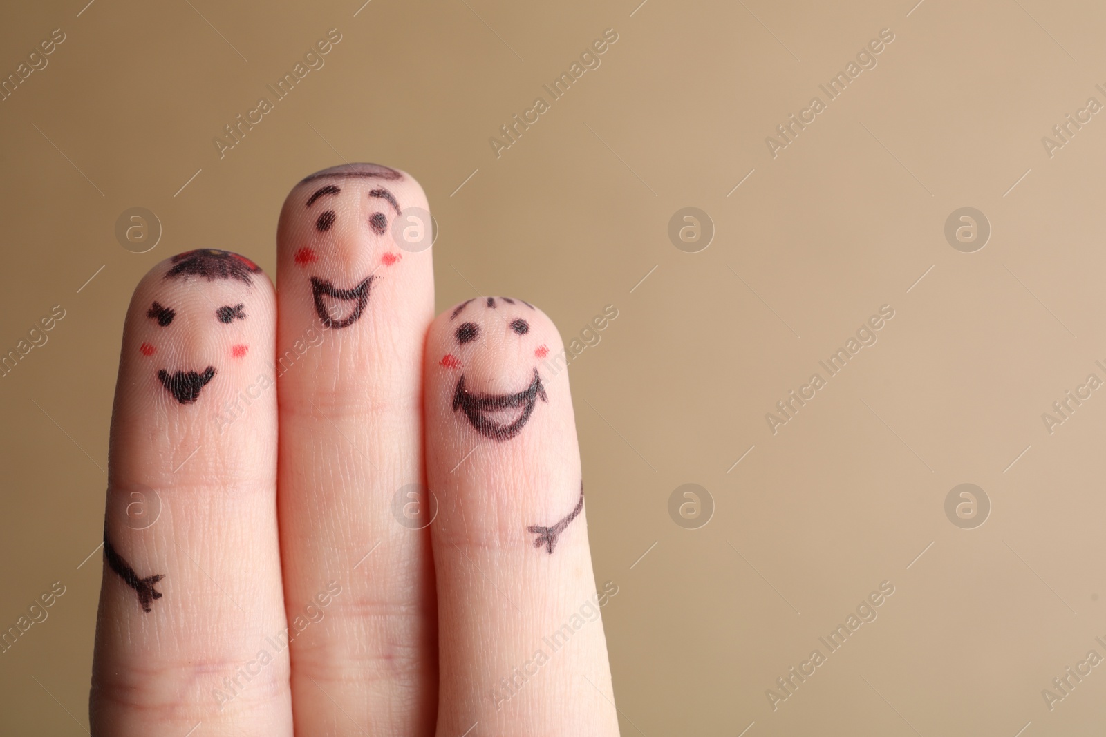 Photo of Three fingers with drawings of happy faces on brown background, space for text