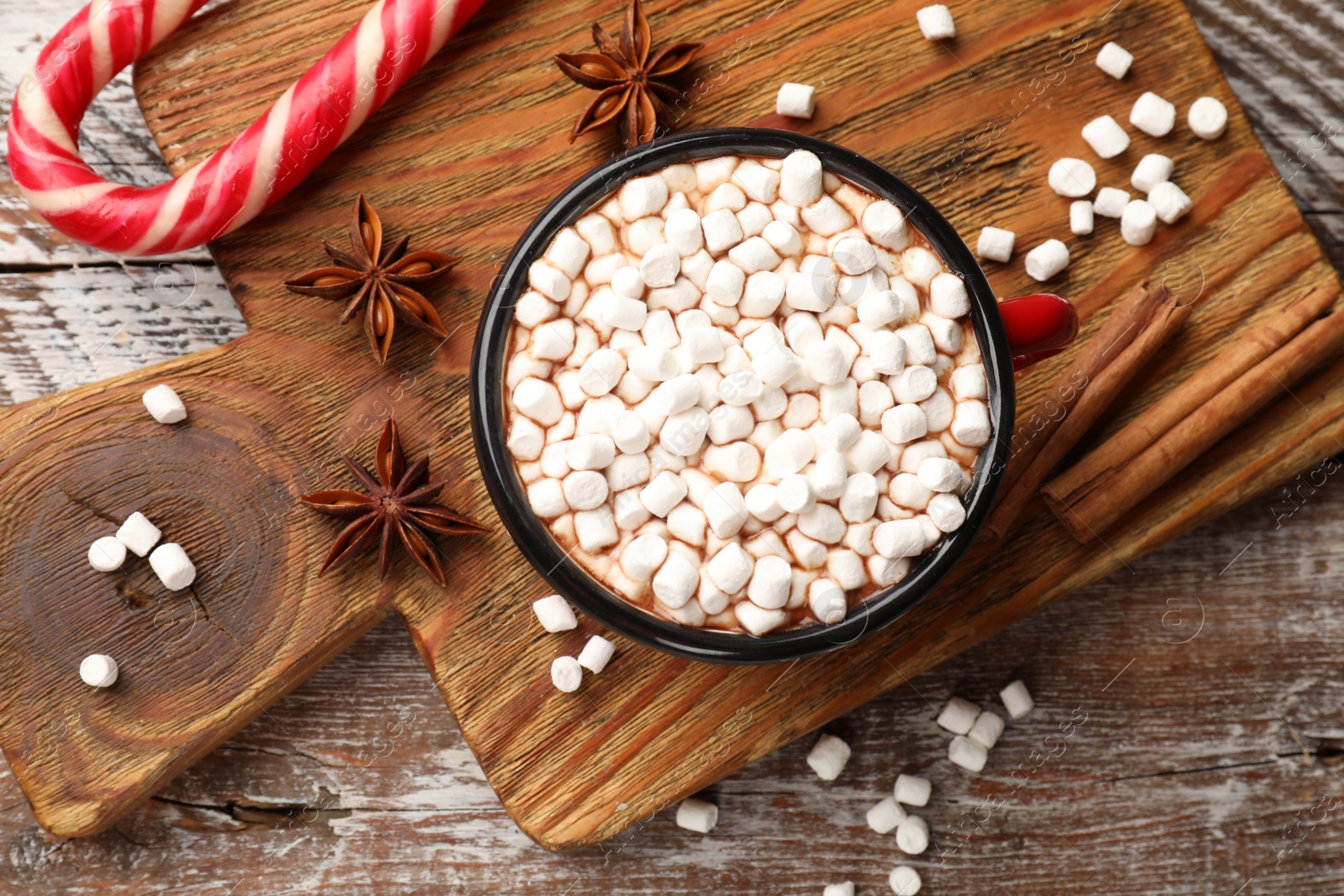 Photo of Tasty hot chocolate with marshmallows on wooden table, top view