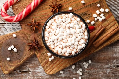 Photo of Tasty hot chocolate with marshmallows on wooden table, top view