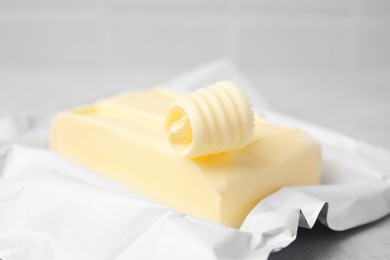 Photo of Tasty butter and curl on light grey table, closeup