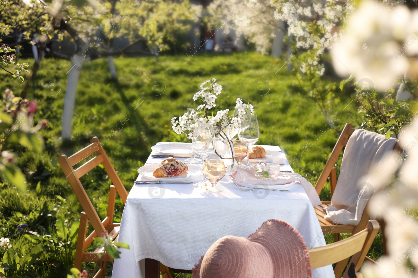 Photo of Beautiful table setting with spring flowers in garden on sunny day