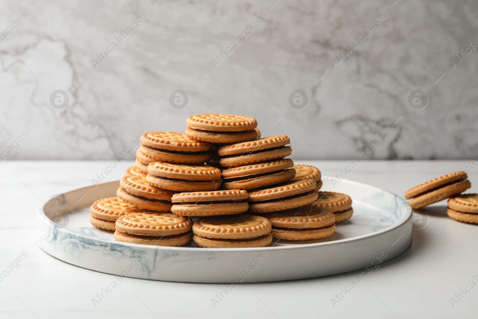 Photo of Tasty sandwich cookies with cream on white table