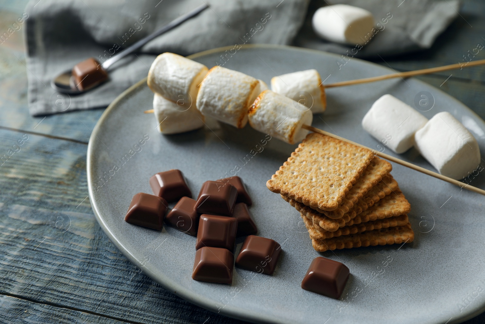 Photo of Ingredients for delicious sandwich with roasted marshmallows and chocolate on grey wooden table, closeup